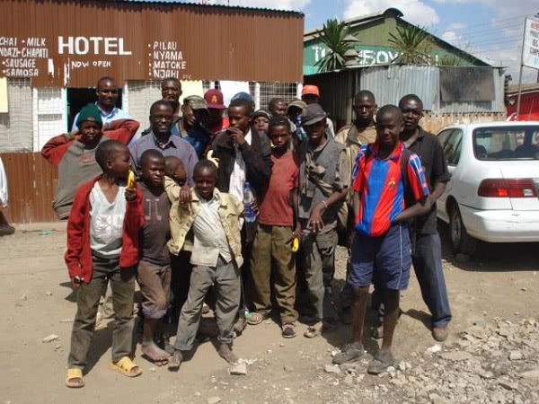 Moses Muthaka am Baugelände, umringt von Buben aus dem Slum